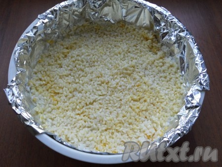 Контейнер для варки на пару застелить фольгой. Иголкой сделать дырочки на дне. Воду с риса слить, а сам рис выложить ровным слоем в контейнер, добавить куркуму и соль. Рис аккуратно перемешать.