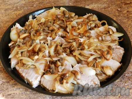Поверх свинины разложить обжаренные грибы с луком.
