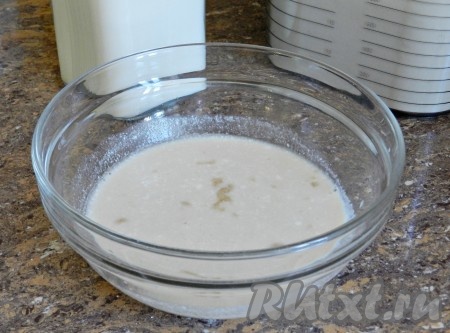 Кислое молоко подогреть. Примерно 150 мл вылить в миску, добавить дрожжи и 0,5 чайной ложки  сахара.