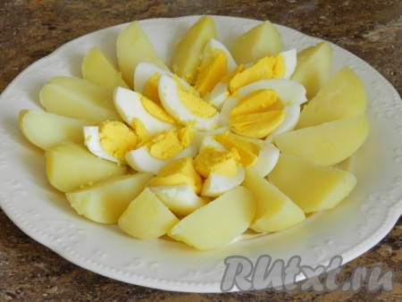 Картофель и яйца нарезать четвертинками, выложить на тарелку.