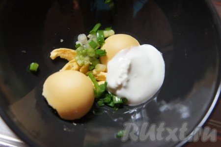 Яйцо разрезать пополам. Желтки размять вилкой, добавить йогурт, мелко нарезанный зелёный лук, соль. Перемешать.