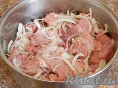 Нарезать свинину на кусочки, смешать с нарезанным полукольцами луком. При этом лук немного подавить руками, чтобы он выделил сок.
