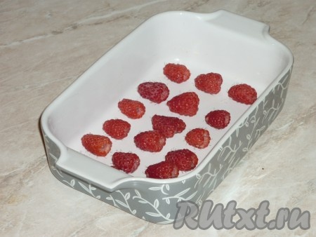 Форму для выпечки смазать сливочным маслом. Выложить вымытые ягоды малины. Для этого десерта можно взять и замороженные ягоды, вначале их нужно разморозить, слить выделившийся сок, а затем использовать по назначению. 
