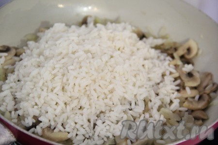 Затем добавить рис в сковороду и перемешать. Посолить по вкусу.