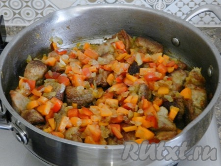 Выложить на сковороду к свинине обжаренные овощи и чеснок, перемешать.
