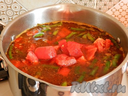 Выложить рис в кастрюлю с мясом и овощами, сверху положить помидоры. Довести до кипения.
