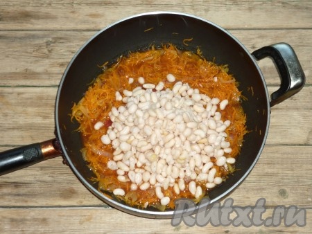 Затем в томатный соус с овощами выложить фасоль, добавить выдавленный через чесночницу чеснок, перемешать и продолжать тушить 10 минут под крышкой на небольшом огне.
