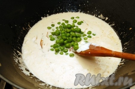 Зальем сливки и добавим зеленый горошек в сковороду с луком и беконом.

