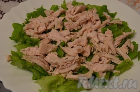 Отварное куриное филе нарезать произвольно. Выложить на листья салата.