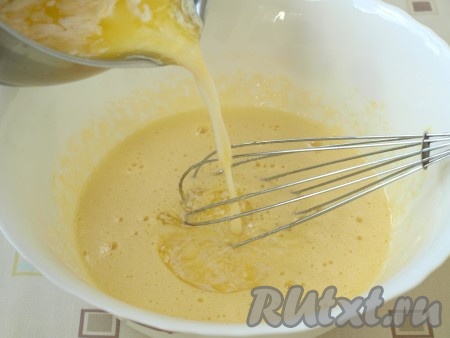 Растопить сливочное масло и, чтобы оно быстрее остыло, влить в него молоко, размешать и добавить в яичную смесь, ещё раз хорошо взбить.
