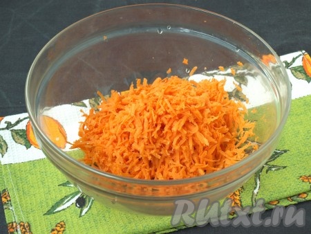 Очистить морковь и натереть её на крупной тёрке. Сложить в глубокую миску.