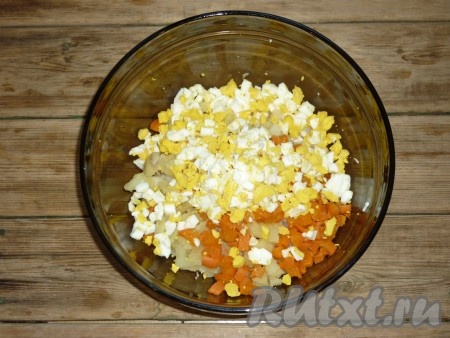 Яйца, сваренные в крутую, нарезать кубиками и отправить в салат к картофелю и морковке. 