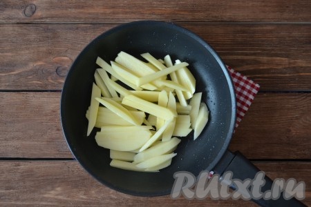 Картофель очистить, вымыть, нарезать соломкой и выложить на полотенце, чтобы ушла лишняя влага. На разогретую сковороду влить масло и нагреть его на протяжении 1 минуты. Выложить картошку.
