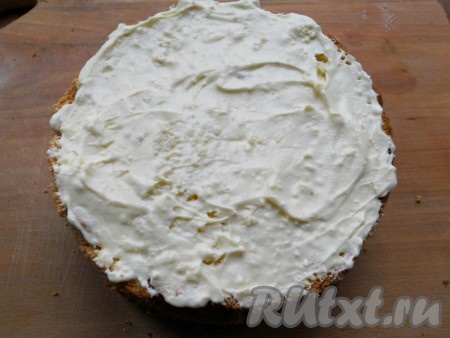 Нижний и средний коржи бисквита смазать масляным кремом, накрыть верхним коржом и немного смазать этим же кремом бока торта. Поместить его в холодильник на 1 час.