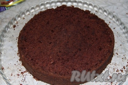 Готовый шоколадный бисквит остудить и разрезать на 2 части.
