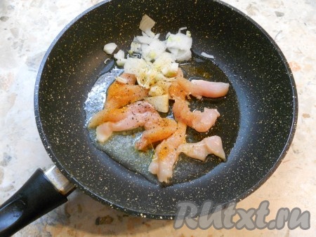 Поместить в сковороду куриное филе, посыпать специями, выложить мелко нарезанный репчатый лук.

