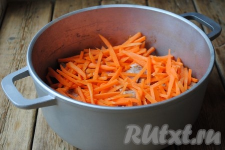 Следом за мясом выложить нарезанную соломкой морковь. 
