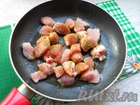 Мякоть свинины нарезать на небольшие кусочки, поместить в разогретую с растительным маслом сковороду, посыпать специями. Обжарить со всех сторон до небольшой румяной корочки.
