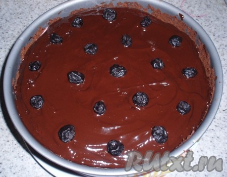Залить торт горячей шоколадной глазурью, украсить вяленой вишней и остудить. 
