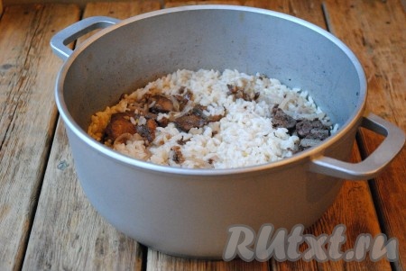 Когда жидкость полностью испарится, как на фото, а рис станет мягким - блюдо готово (рис должен свариться, но не перевариться). 
