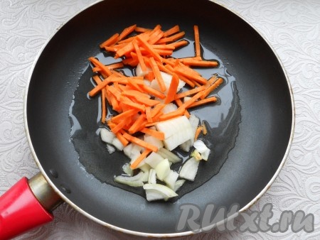 Лук и морковь очистить. Лук, нарезанный небольшими кусочками,  и нарезанную соломкой морковь выложить на сковороду, разогретую с растительным маслом.