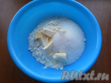 Для приготовления теста к просеянной муке добавить холодное, нарезанное кусочками, сливочное масло, всыпать сахар.
