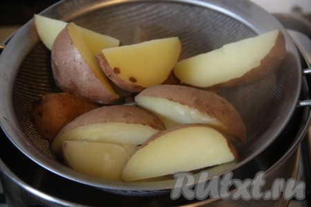 Картофель тщательно вымыть и, не очищая, разрезать на 8 долек. Залить картофель водой, слегка посолить и сварить до готовности (в течение 15-20 минут). Готовую картошку откинуть на дуршлаг, чтобы стекла вода. 
