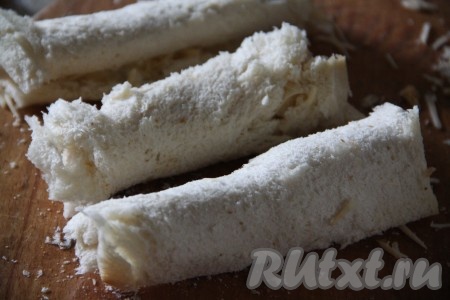 Скрутить каждый тостовый хлеб с сыром в рулетик.
