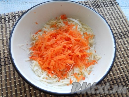 Морковь, натерев на крупной терке, выложить к нашинкованной капусте.