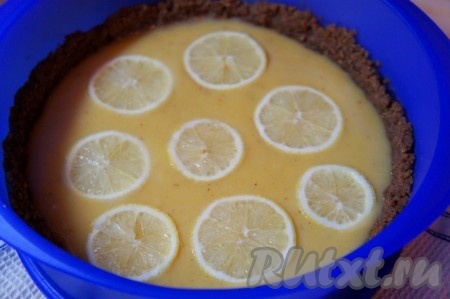 Вылить заварной крем на основу из печенья, разровнять, украсить кусочками лимона и поставить торт из печенья в холодильник на 2-3 часа.
