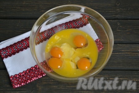 В глубокой миске соединить подтаявшее сливочное масло и 4 куриных яйца. Если использовать домашние яйца - в результате кексы будут насыщенного желтого цвета. 

