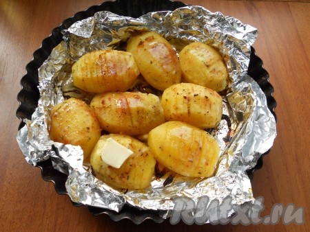 Накрыть форму листом фольги и отправить картофель в разогретую до 180 градусов духовку. Запекать при этой температуре около 35-40 минут. Затем верхнюю фольгу убрать, на каждую картофелину выложить по маленькому кусочку сливочного масла.