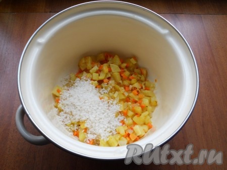 Обжарить овощи в течение 5 минут, помешивая. Выложить обжаренные овощи в кастрюлю, всыпать промытый рис.
