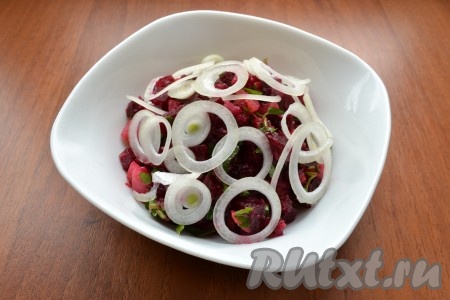 Далее салат выложить в салатник, сверху разместить нарезанный тонкими кольцами репчатый лук.
