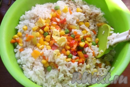 К рису добавить овощи и яйца, перемешать.
