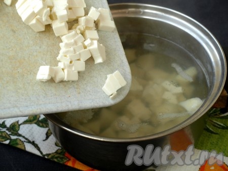 Кубиками нарезать плавленный сырок. Когда картофель сварится, в кастрюлю выложить кубики сыра, размешать до полного растворения.

