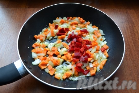 Обжарить лук с морковью в течение 3-4 минут, помешивая, на небольшом огне. Далее добавить в сковороду нарезанный соломкой или кубиками сладкий болгарский перец, предварительно очищенный от семян.