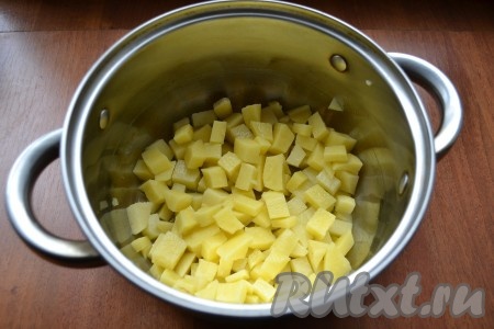 Картофель очистить и нарезать кубиками прямо в кастрюлю. Залить водой, довести до кипения, затем огонь уменьшить, посолить и варить картошку 15 минут.