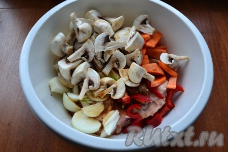 К бедрышкам добавить шампиньоны, нарезанные на 2-4 части, крупно нарезанные лук и морковь, а также сладкий болгарский перец кусочками, влить соевый соус.
