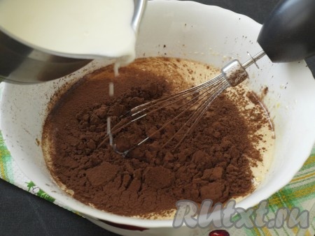 Добавить растительное масло, ещё раз взбить, просеять какао и добавить едва тёплое молоко.
