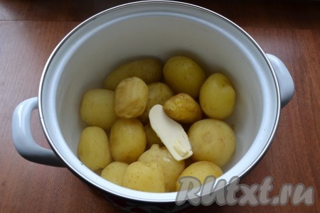 Когда картошка сварится, воду слить. В картофель добавить сливочное масло, накрыть кастрюлю крышкой и хорошенько встряхнуть, чтобы масло разошлось.