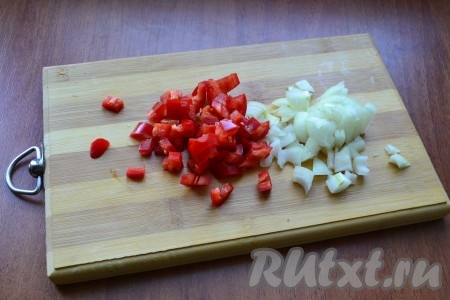 Лук и чеснок очистить, удалить семена и плодоножку из болгарского перца. Лук и болгарский перец нарезать небольшими кубиками.
