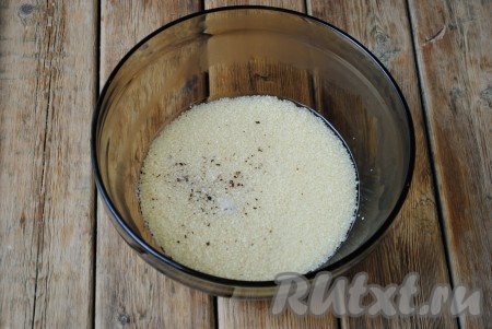 1 стакан кускуса всыпать в термостойкую посуду, добавить соль и чёрный молотый перец, перемешать, залить 1,5 стаканами кипятка, накрыть крышкой и оставить на 3-5 минут, чтобы крупа набухла. 