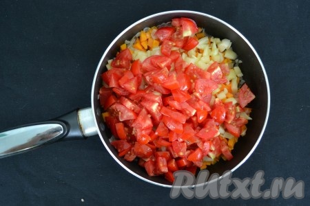 На помидорах сделать крестовые надрезы, обдать кипятком и через минуту снять кожицу. Нарезать очищенные помидоры мелкими кубиками и отправить в сковороду следом за перцем. 

