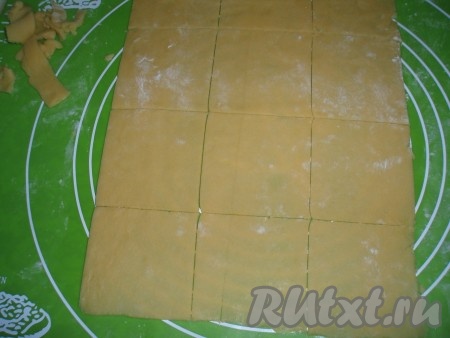 На столе, присыпанном мукой, или на силиконовом коврике охлажденное тесто раскатать в пласт толщиной, примерно, 3 мм. Нарезать раскатанное тесто на квадраты со стороной 6-7 см.
