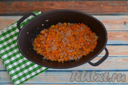 Очищенные лук и морковь нарезать мелкими кубиками. Разогреть казан или сковороду на огне, влить растительное масло, а через минуту выложить морковку с луком и обжарить в течение 2-3 минут на среднем огне, иногда помешивая.