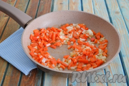 Очистить лук, нарезать мелкими кубиками. Болгарский перец вымыть, убрать семена и плодоножку, нарезать кубиками. Разогреть сковороду, влить растительное масло, через минуту выложить лук с перцем и, помешивая, обжаривать 2-3 минуты.
