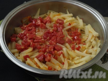 Очистить от шкурки помидор, нарезать кубиками и добавить его в сковороду, блюдо посолить и протушить кольраби ещё 10 минут под крышкой, периодически перемешивая.
