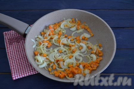 Очистить лук и морковь. Лук нарезать тонкими полукольцами, а морковь - небольшими кубиками. В сковороду влить растительное масло и через минуту выложить овощи. Помешивая, обжарить лук с морковью на среднем огне в течение 2 минут.
