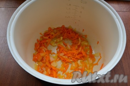 Влить в чашу мультиварки растительное масло и выставить на 35 минут программу "Выпечка". Выложить в чашу натертую на крупной терке морковь и нарезанный мелко лук, готовить 10 минут, периодически перемешивая.
